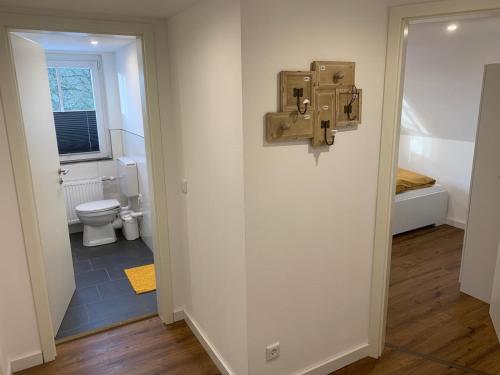 a bathroom with a toilet and a window and a door at Ferienwohnungen Berghaus - 2 komfortable Appartements für bis zu 7 Personen in Schmallenberg
