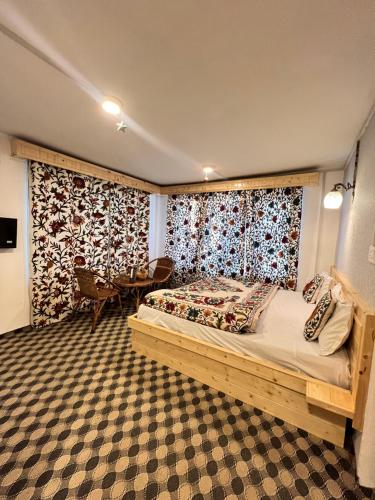 a bedroom with a bed and a table at The AISHANA PAHALGAM in Pahalgām