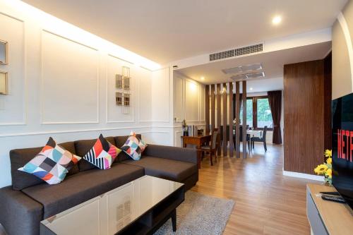 a living room with a couch and a dining room at Elegancy Resort Hua Hin in Hua Hin