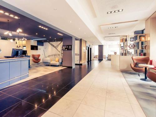 a lobby of a building with chairs and tables at Mercure Hotel Hamburg Mitte in Hamburg