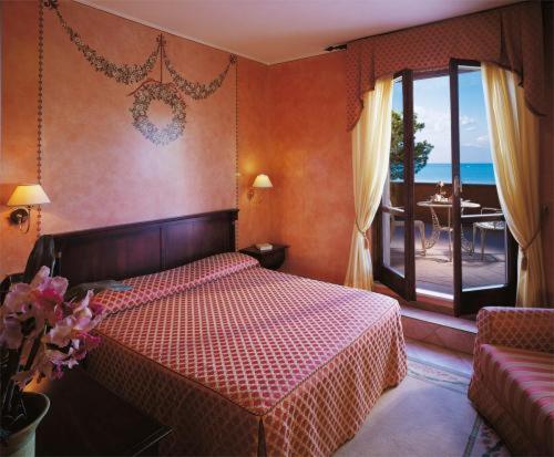 a bedroom with a bed and a view of the ocean at Hotel Lugana Parco Al Lago in Sirmione