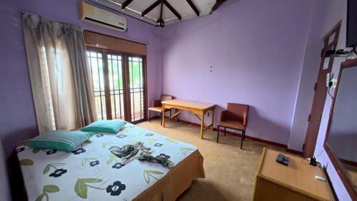 a bedroom with a bed and a table and a desk at Iris Grand Hotel in Nittambuwa