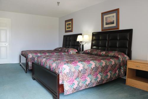 a hotel room with two beds and a table at Bent Tree Motel in Emory