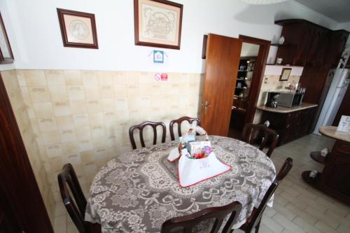 a dining room table with a doll sitting on top of it at Nandes Place in Praia da Vitória