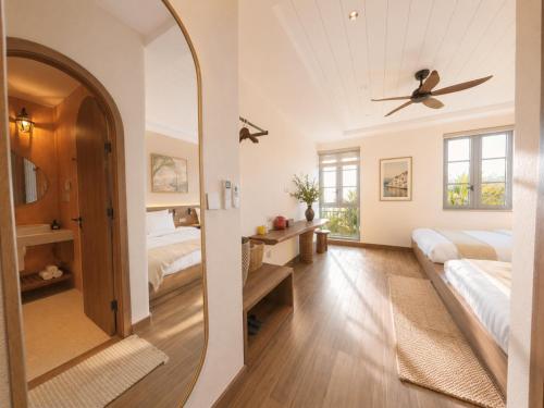 a bedroom with two beds and a mirror at Vistalago Hotel Khem Beach Phu Quoc in Phú Quốc