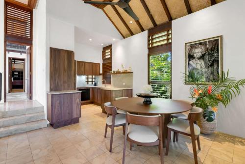 a kitchen and dining room with a table and chairs at Monsoon Villa A - Central Balinese-style Pool Oasis in Port Douglas