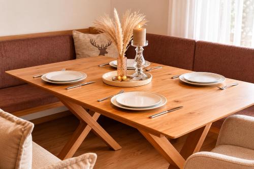 a wooden table with plates and utensils on it at Michelis Cottage - Achensee in Pertisau
