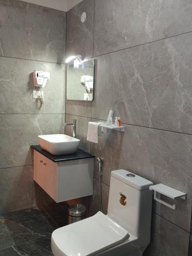 a bathroom with a white toilet and a sink at Aruvi on the cliff in Varkala