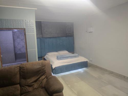 a living room with a bed and a couch at Co operville in Potchefstroom