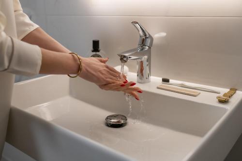 a woman is washing her hands under a sink at Arden House in Dingle