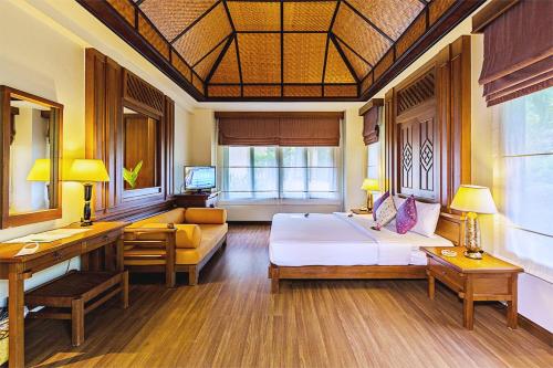 a bedroom with a bed and a couch in a room at The Fair House Beach Resort & Hotel in Chaweng Noi Beach