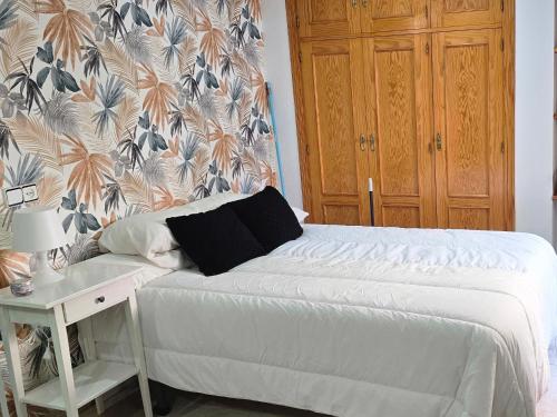 a bedroom with a bed and a desk with a wall at apto La Campana in Toledo