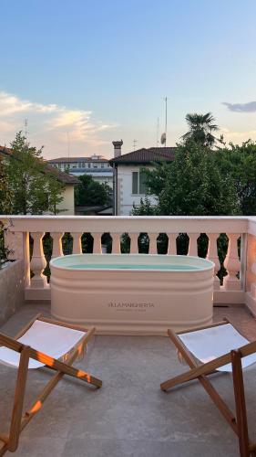 a hot tub sitting on a balcony with two chairs at B&B Villa Margherita - Luxury Rooms in Padua in Padova