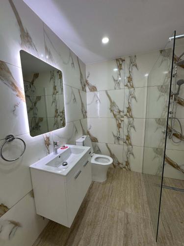 a bathroom with a sink and a toilet and a mirror at WHTheGroundNest in Paralimni