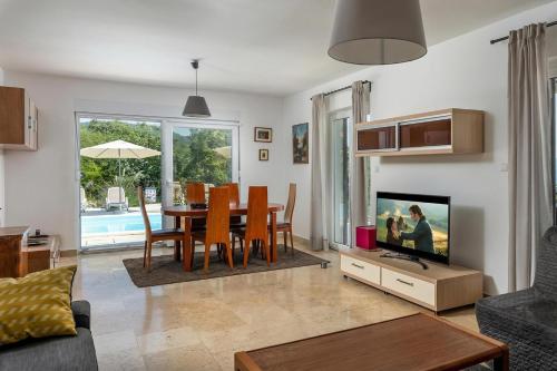 a living room with a dining table and a tv at Hillside Villa Kvarner: Pool & Sea View - Happy Rentals in Ičići