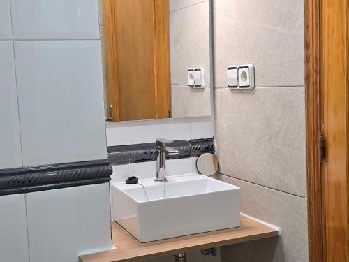 a bathroom with a white sink and a mirror at apto La Campana in Toledo