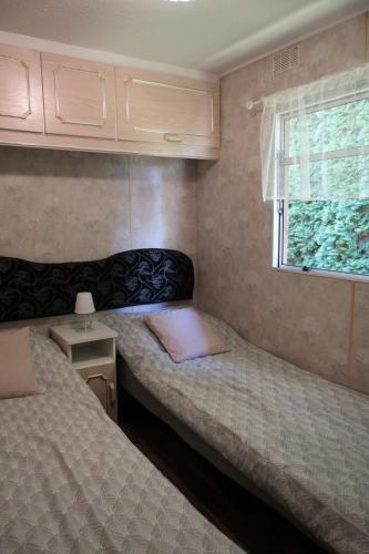 two beds in a small room with a window at Kalva Sumowo in Sumowo