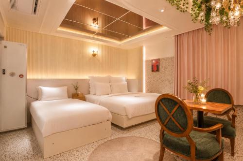 a hotel room with two beds and a table at Daegu February Hotel DongdaeguStation in Daegu