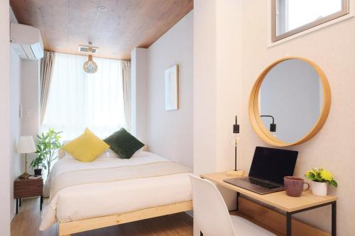 a bedroom with a bed and a desk with a mirror at Dearcourt Kichijoji 1F-3F in Musashino