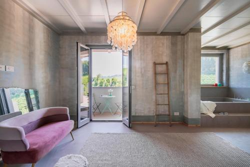 a living room with a pink couch and a chandelier at L'Attico di Asilo in Barolo in Barolo