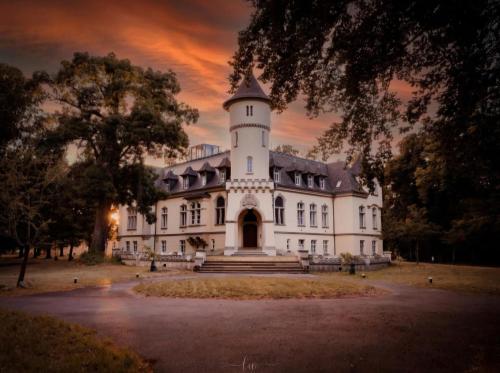 a large white building with a tower on top at Schlosshotel Hohenbocka in Hohenbocka