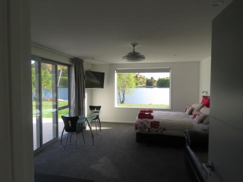 a bedroom with a bed and a view of a lake at Cromwell Escape in Cromwell