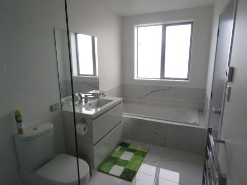 a bathroom with a shower sink and a toilet at Cromwell Escape in Cromwell