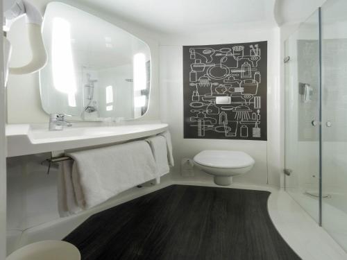 a bathroom with a sink and a toilet and a mirror at ibis Rouen Centre Champ de Mars in Rouen