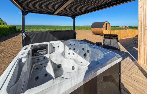 a large bath tub sitting under a cover on a deck at Gorgeous Home In Haderslev With Sauna in Haderslev