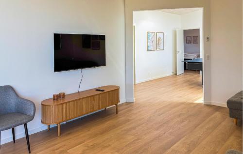 a living room with a table and a tv on a wall at Gorgeous Home In Haderslev With Sauna in Haderslev