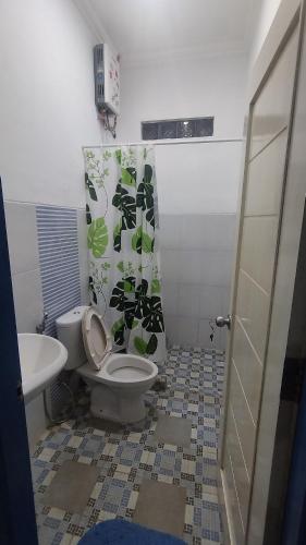 a bathroom with a toilet and a sink at Rumah Senden Guesthouse in Yogyakarta