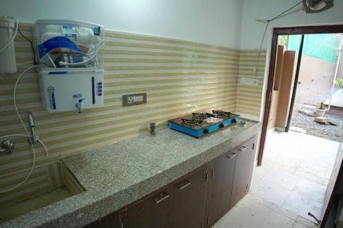 a kitchen with a counter top with a stove at Saanjh Private Pool Villa Jaipur in Jaipur