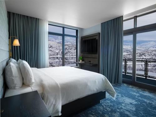 a bedroom with a large bed and large windows at Grand Hyatt Deer Valley in Park City