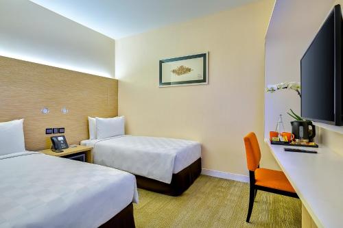 a hotel room with two beds and a desk at Sama-Sama Express KLIA Terminal 2 - Airside Transit Hotel in Sepang