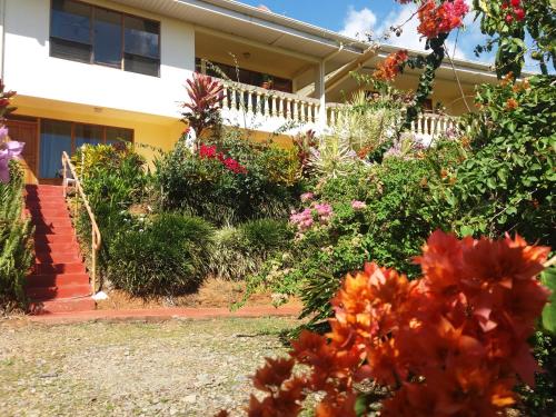 a house with a bunch of flowers in front of it at La Princesa Hotel in San Isidro