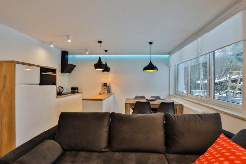 a living room with a couch and a kitchen at Apartamenty MISTRAL in Karpacz