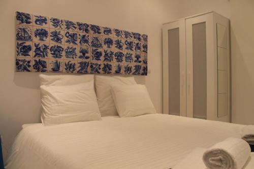 リスボンにあるBairro Alto 27のベッドルーム1室(白と青の壁の白いベッド1台付)