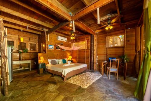 a bedroom with a bed in a room with wooden walls at Mar Villa Eco Lodge Surf & Kite Perla Marina by Encuentro Beach in Sosúa