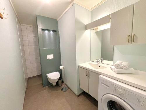 a small bathroom with a toilet and a sink at Fjord Apartments in Dimmelsvik
