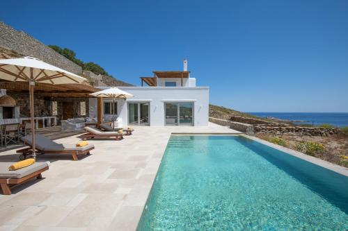 a villa with a swimming pool and a house at Villa Sozon Mykonos in Agios Sostis Mykonos