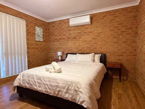 a bedroom with a bed with a teddy bear on it at Good price Apartment self check-in in Geraldton