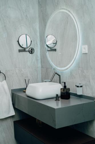 a bathroom with a white sink and a mirror at The Gardens in Marracuene