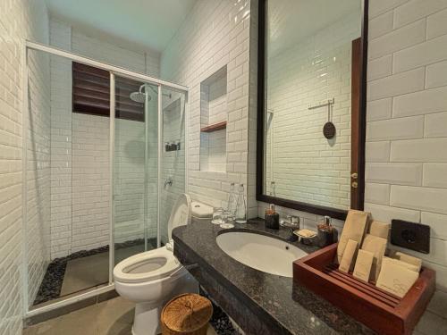 a bathroom with a toilet and a sink and a shower at Plataran Puncak Residences in Puncak