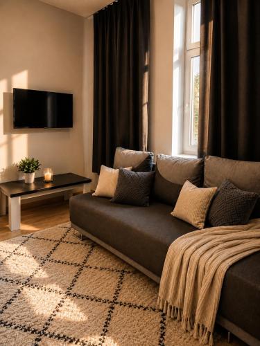 a living room with a couch and a tv at MieszkaStreet kawalerka in Gniezno