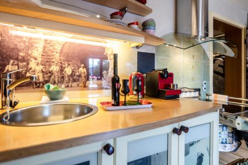 a kitchen counter with a sink and a bottle of wine at Romantische 5-Sterne- Ferienwohnungen in Mittenwald