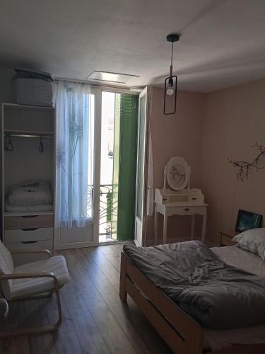 a bedroom with a bed and a sliding glass door at T2 Cosy, agréable fonctionnel et douillet, 1 lit 140 et un BZ , Wifi gratuit, boîte à clés, proche commerces et gare routière, linge de lit et toilette offerts à partir de 4 nuits in Graulhet