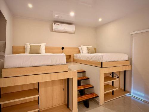 a small room with two beds and a desk at Cumaé Hotel Boutique in Quimbaya