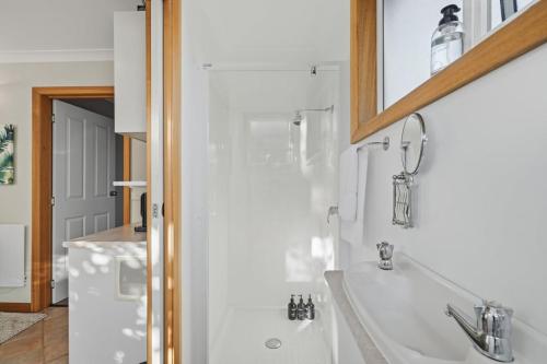 a bathroom with a sink and a mirror at Sunlit Garden Granny Flat in Devonport