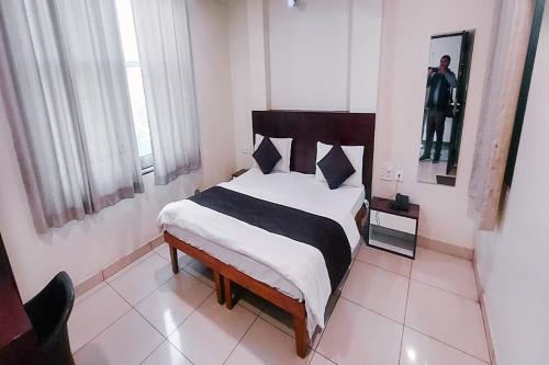 a bedroom with a bed with a black and white blanket at Hotel Rashika Palace Near Sindhi Camp Bus Stand, Jaipur in Jaipur