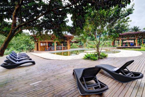 a group of black chairs sitting on a deck with a pool at Banana Bamboo Ecolodge in Ubatuba